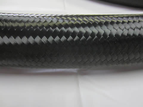 Una manguera hidráulica SAE 100R5 de color negro y podemos ver la cubierta trenzada de fibra suave y brillante.