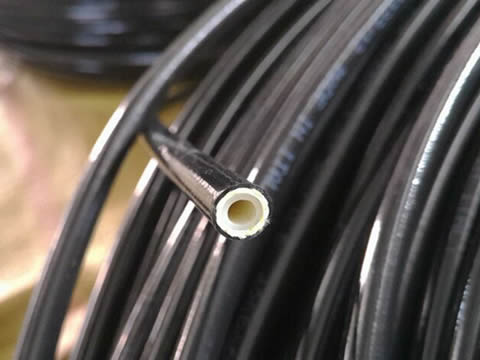 A roll of SAE 100R8 hydraulic hose shows the detail section of inner tube and reinforcement layer.